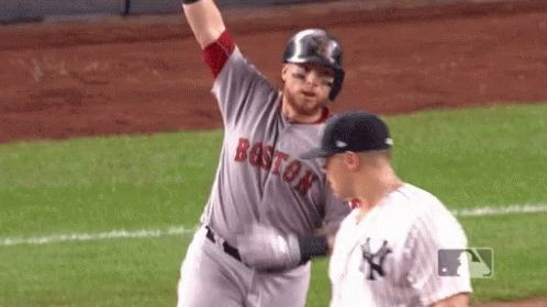 A Baseball Player From The Boston Red Sox Is Standing Next To A Yankees Player On The Field . GIF