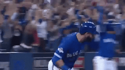A Baseball Player In A Blue Uniform Is Hugging Another Player On A Baseball Field . GIF
