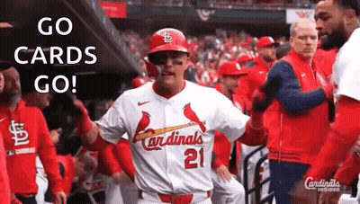 A Baseball Player In A Cardinals Uniform Is Standing In The Dugout With His Teammates . GIF