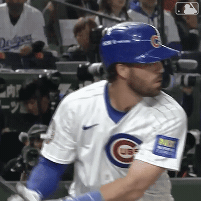 A Baseball Player In A Cubs Uniform Is Swinging His Bat At A Pitch . GIF