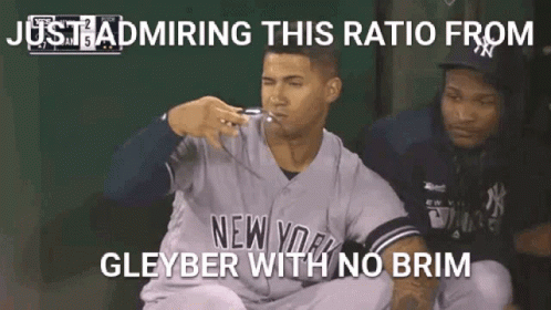 A Baseball Player In A New York Yankees Uniform Is Sitting In The Dugout With His Mouth Open . GIF