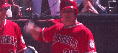 A Baseball Player In A Red Uniform Is Swinging A Bat At A Ball In A Dugout . GIF