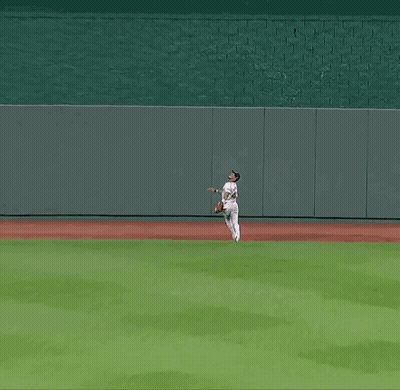 A Baseball Player In A White Uniform Is Running On A Baseball Field GIF