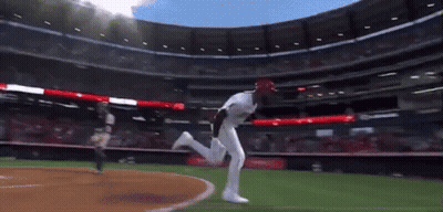 A Baseball Player In A White Uniform Is Running On A Field GIF