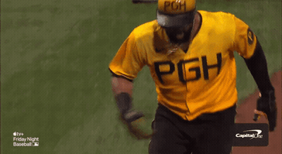 A Baseball Player In A Yellow Uniform Is Being Congratulated By A Group Of People GIF