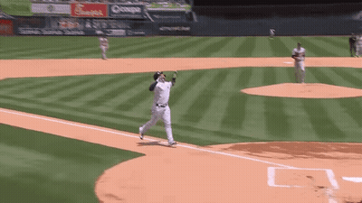 A Baseball Player Is Catching A Ball On A Field GIF