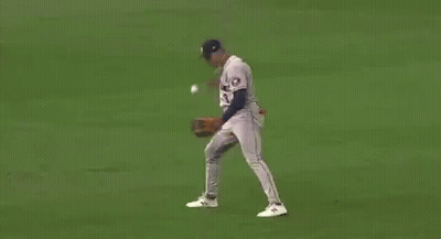 A Baseball Player Is Catching A Ball On The Field . GIF