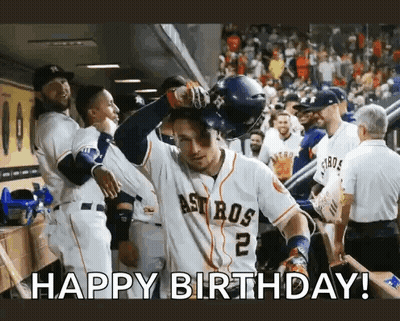 A Baseball Player Is Celebrating His Birthday In The Dugout While His Teammates Congratulate Him . GIF