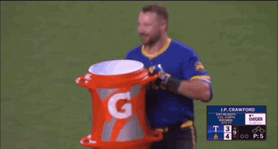 A Baseball Player Is Holding A Gatorade Bucket On The Field . GIF