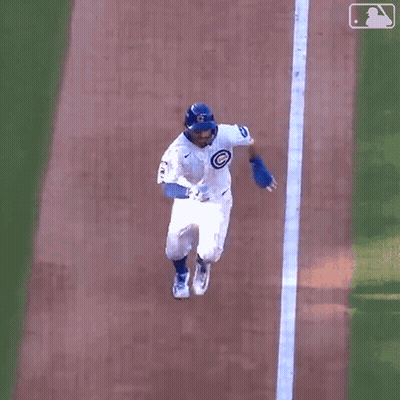 A Baseball Player Is Laying On The Ground On His Back . GIF