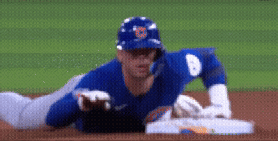 A Baseball Player Is Laying On The Ground On The Field GIF