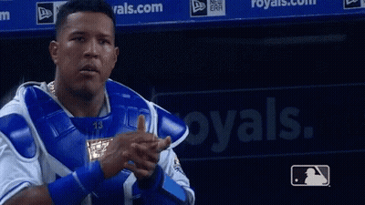 A Baseball Player Is Pointing At The Camera In Front Of A Royals Sign GIF