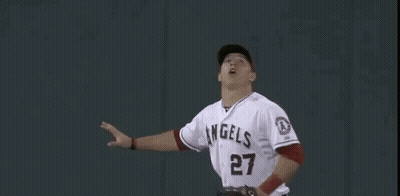 A Baseball Player Is Reaching Up To Catch A Ball In Front Of A Wall With The Number 400 On It . GIF