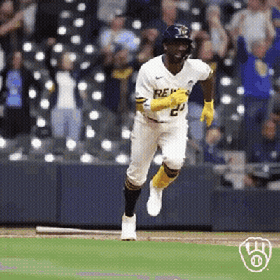 A Baseball Player Is Running On A Baseball Field With A Bat . GIF
