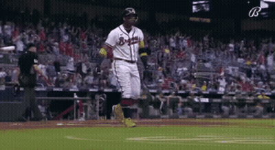 A Baseball Player Is Running On The Field During A Baseball Game . GIF