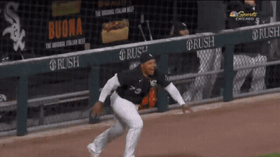 A Baseball Player Is Running On The Field In Front Of A Banner For Buona GIF