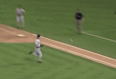 A Baseball Player Is Running Towards A Base While A Catcher Is Kneeling Down . GIF