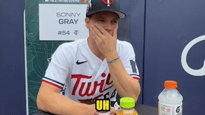 A Baseball Player Is Sitting At A Table With His Hand On His Face . GIF