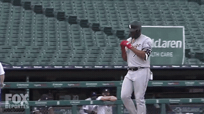A Baseball Player Is Standing In Front Of A Green Sign That Says Mclaren Healthcare GIF