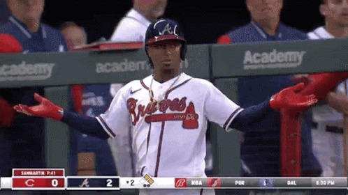 A Baseball Player Is Standing In The Dugout During A Game . GIF