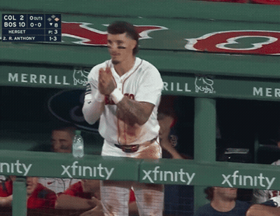 A Baseball Player Is Standing In The Dugout With Blood On His Shirt And A Sign That Says Xfinity GIF
