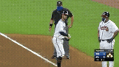 A Baseball Player Is Standing On A Field With A Referee . GIF