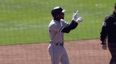 A Baseball Player Is Standing On A Field With His Arms In The Air . GIF