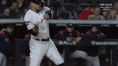 A Baseball Player Is Swinging A Bat At A Ball In A Baseball Game . GIF