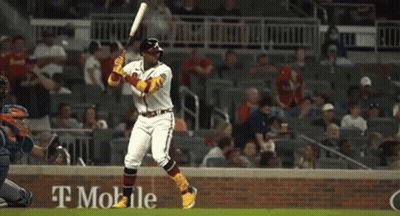 A Baseball Player Is Swinging A Bat At A Ball In A Stadium Sponsored By T-Mobile . GIF