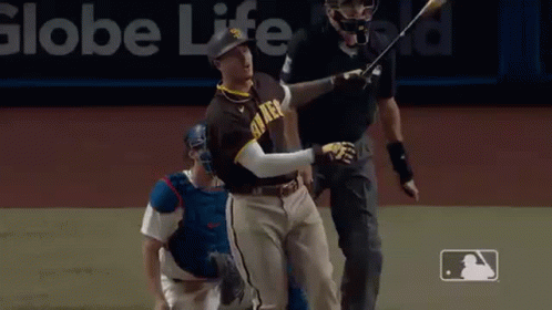 A Baseball Player Is Swinging A Bat At A Ball While A Catcher Looks On . GIF