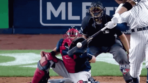 A Baseball Player Is Swinging A Bat At A Ball With A Mlb Logo In The Background GIF
