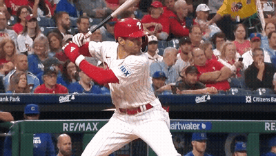 A Baseball Player Is Swinging A Bat In Front Of A Re / Max Banner GIF