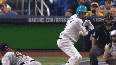 A Baseball Player Is Swinging At A Ball In Front Of A Marlins.com/offers Sign GIF