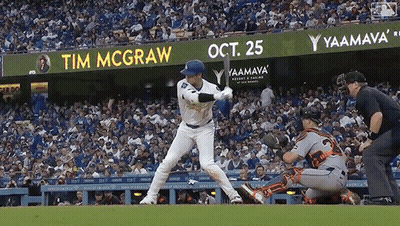 A Baseball Player Is Swinging At A Ball In Front Of A Sign That Says Tim Mcgraw GIF