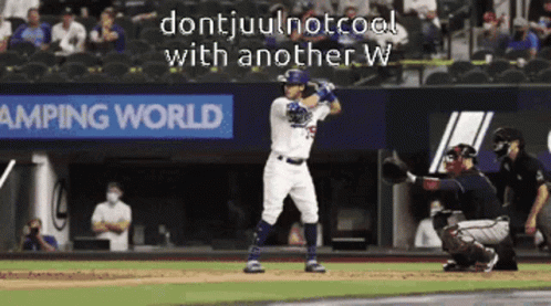 A Baseball Player Is Swinging At A Pitch In Front Of A Banner For Camping World GIF