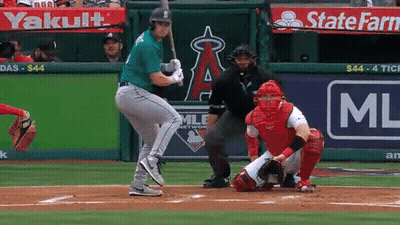 A Baseball Player Is Swinging His Bat At A Ball In Front Of A State Farm Ad GIF