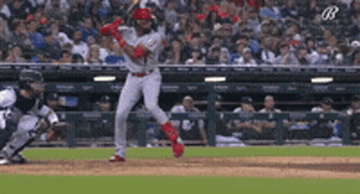 A Baseball Player Is Swinging His Bat At A Pitch During A Game GIF