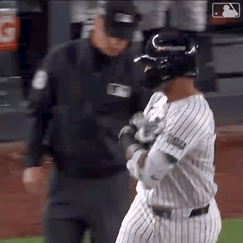 A Baseball Player Is Talking To A Referee While Wearing A Helmet GIF
