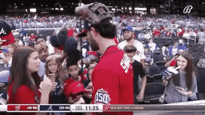 A Baseball Player Is Talking To A Woman In The Stands During A Game . GIF