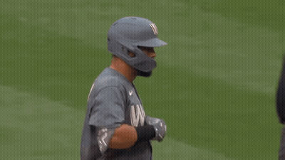 A Baseball Player Is Talking To An Umpire While Wearing A Helmet . GIF