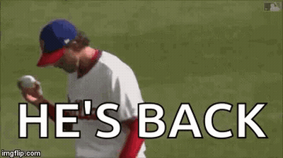 A Baseball Player Is Throwing A Ball On A Field With The Words `` He 'S Back '' . GIF