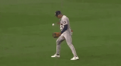 A Baseball Player Is Trying To Catch A Ball On A Field . GIF