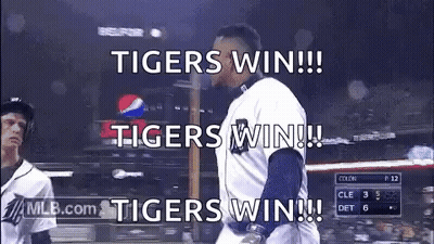 A Baseball Player Is Walking Towards The Dugout With The Words `` Tigers Win !!! '' Written On The Screen . GIF