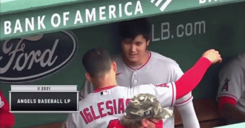 A Baseball Player Named Iglesias Is Hugging Another Player In The Dugout . GIF