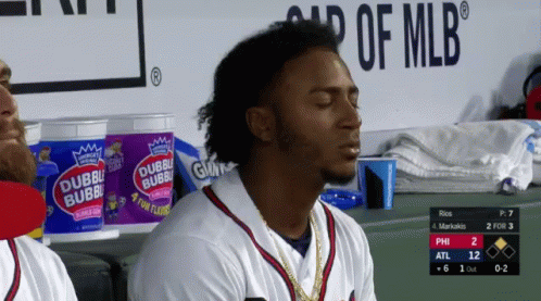 A Baseball Player Sits In The Dugout With His Eyes Closed In Front Of A Bucket Of Double Bubble Gum GIF