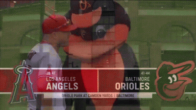 A Baseball Player Standing Next To A Mascot On A Baseball Field . GIF