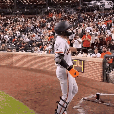 A Baseball Player Stands In Front Of A Crowd With The Number 24 On The Wall Behind Him GIF