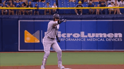 A Baseball Player Stands In Front Of A Microlumen Advertisement GIF