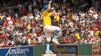 A Baseball Player Stands On A Base In Front Of A Jordan 'S Furniture Advertisement GIF