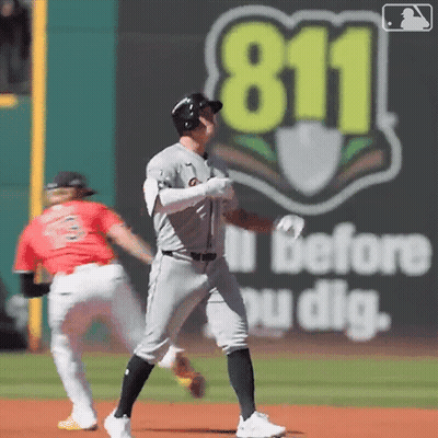 A Baseball Player Stands On The Field In Front Of A 911 Sign GIF